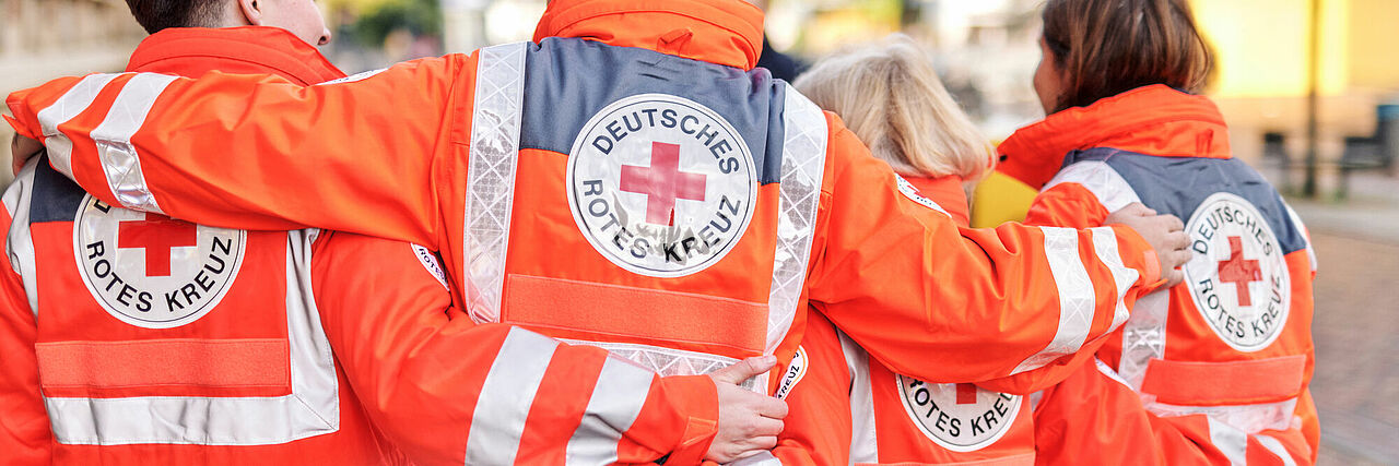 Team des DRK in Einsatzjacken, Ansicht von hinten Team des DRK in Einsatzjacken, Ansicht von hinten